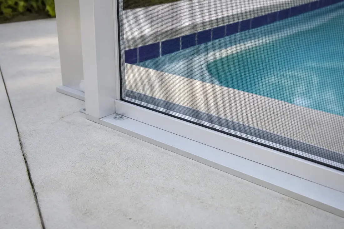 The base of a pool enclosure frame where it meets the deck