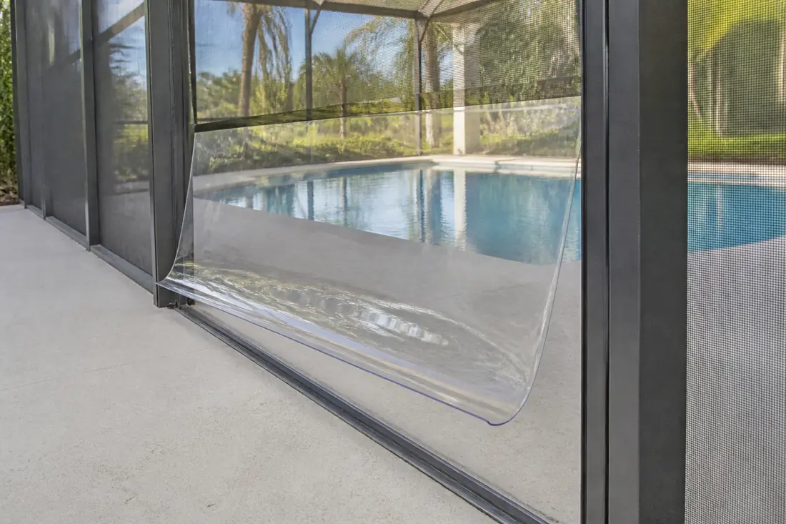 A clear vinyl wind break panel lifted part way out of its aluminum track