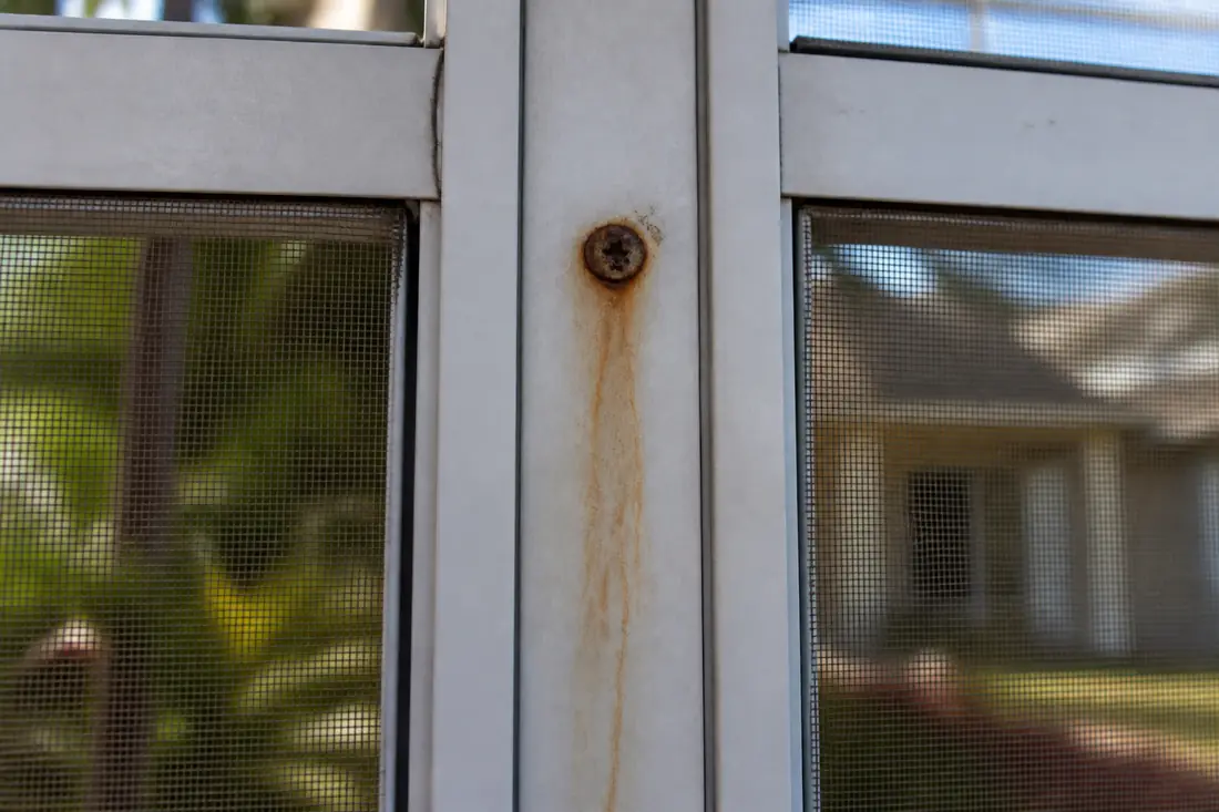 A corroded fastener at a frame joint on a screen enclosure